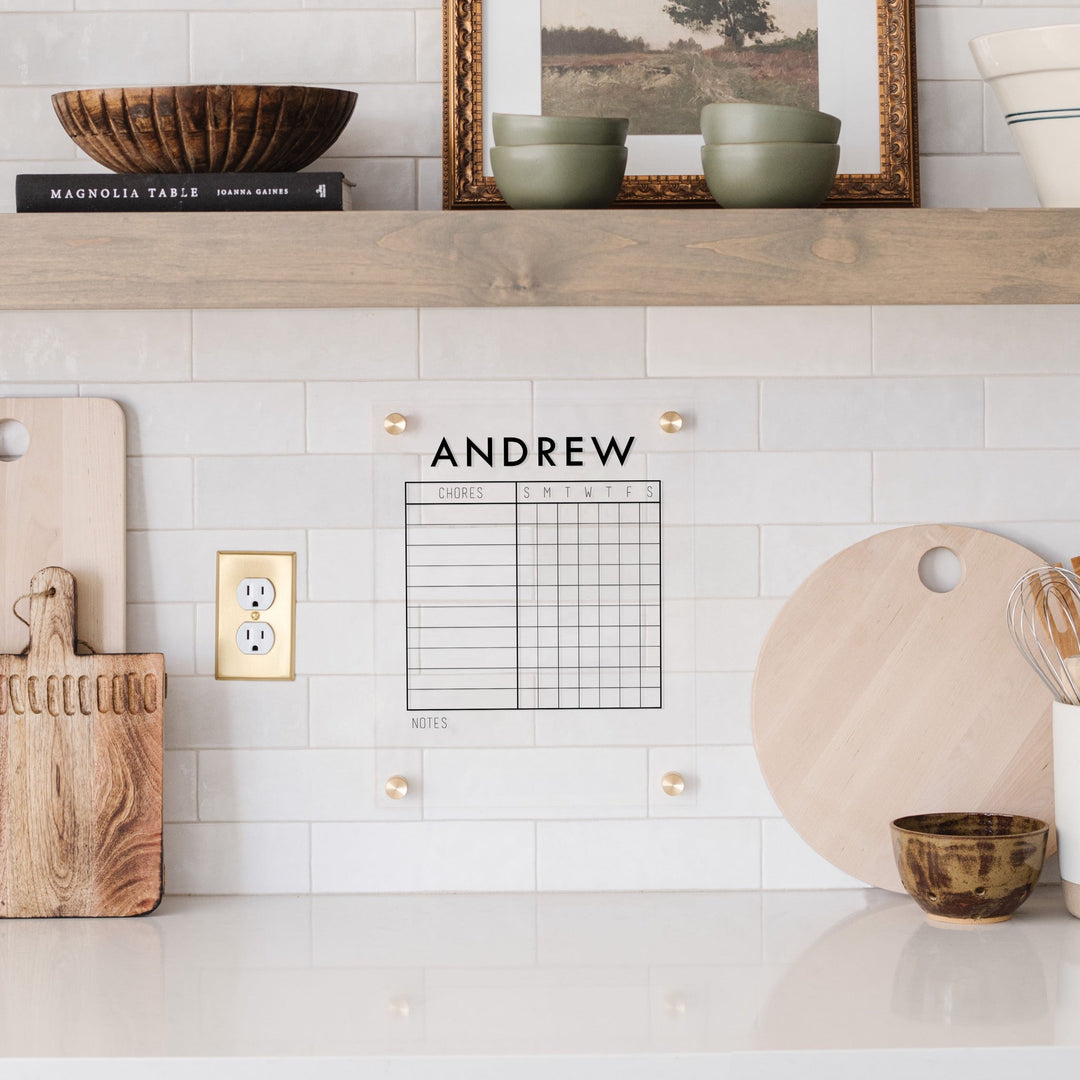 A Dry-erase acrylic chore chart hanging on the wall