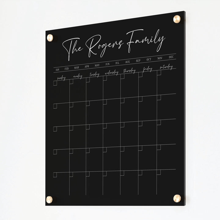A Dry-erase monthly calender made of acrylic hanging on the wall