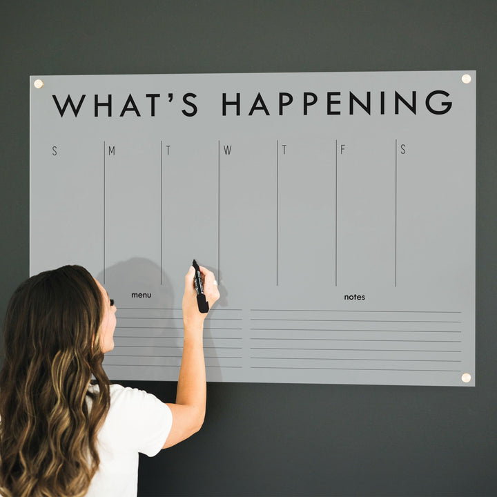 A Dry-erase weekly calender made of acrylic hanging on the wall
