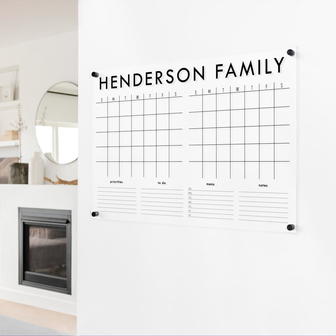 A Dry-erase acrylic calendar with a two month design format hanging on the wall