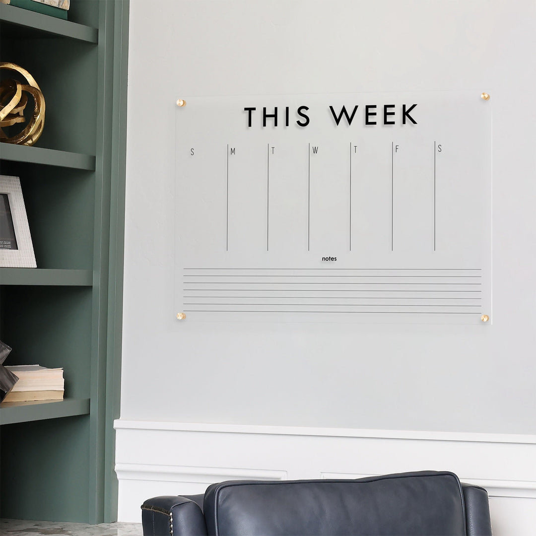 A Dry-erase weekly calender made of acrylic hanging on the wall