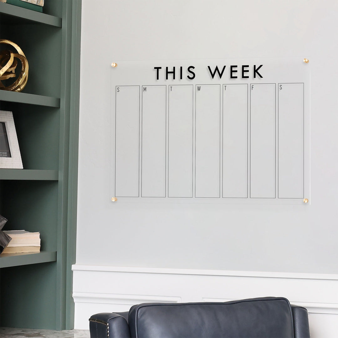 A Dry-erase weekly calender made of acrylic hanging on the wall