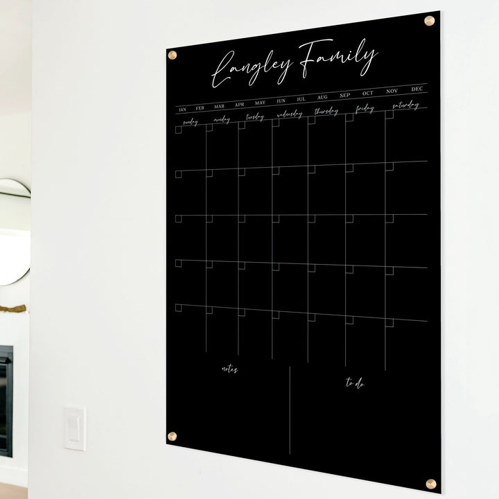 A Dry-erase monthly calender made of acrylic hanging on the wall