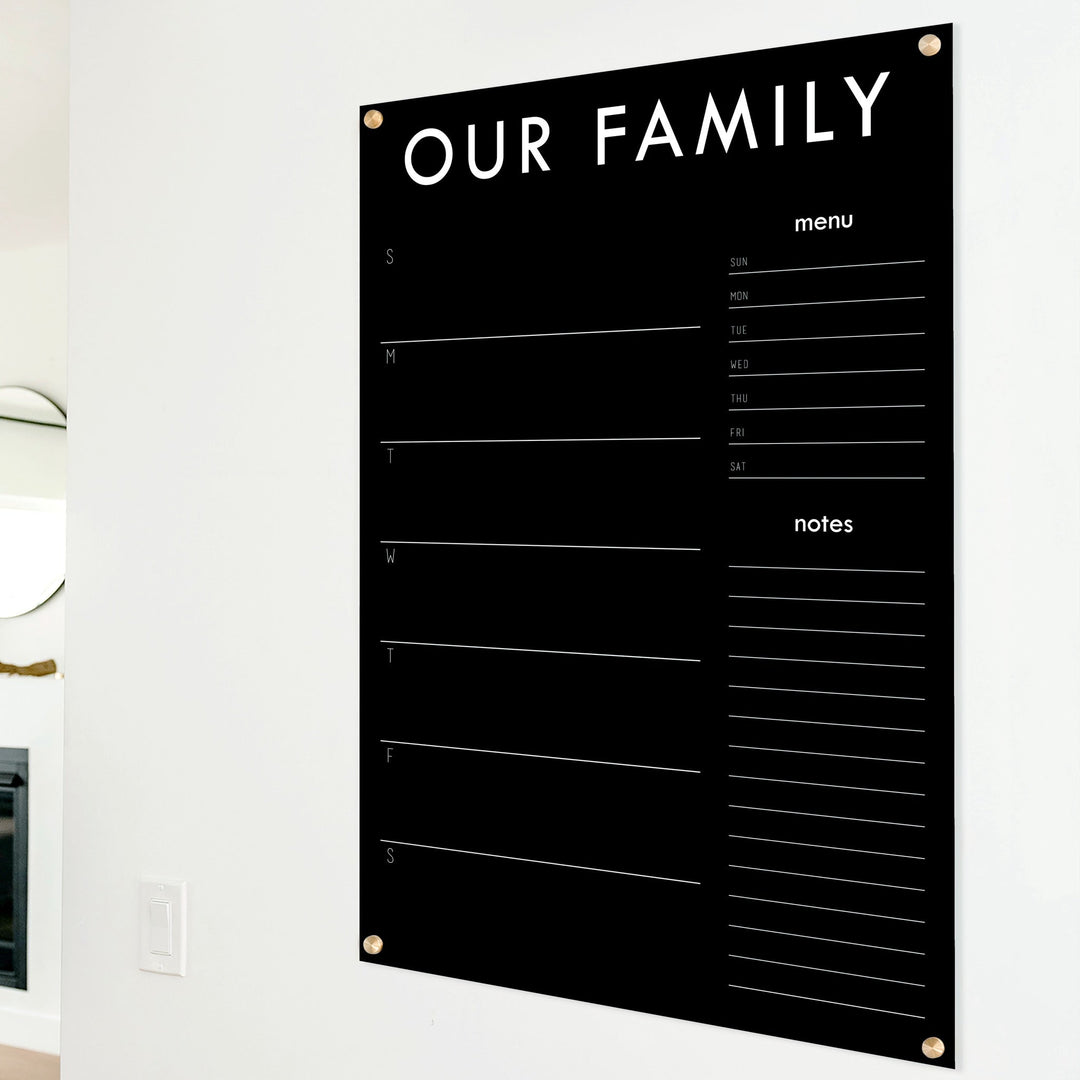 A Dry-erase weekly calender made of acrylic hanging on the wall