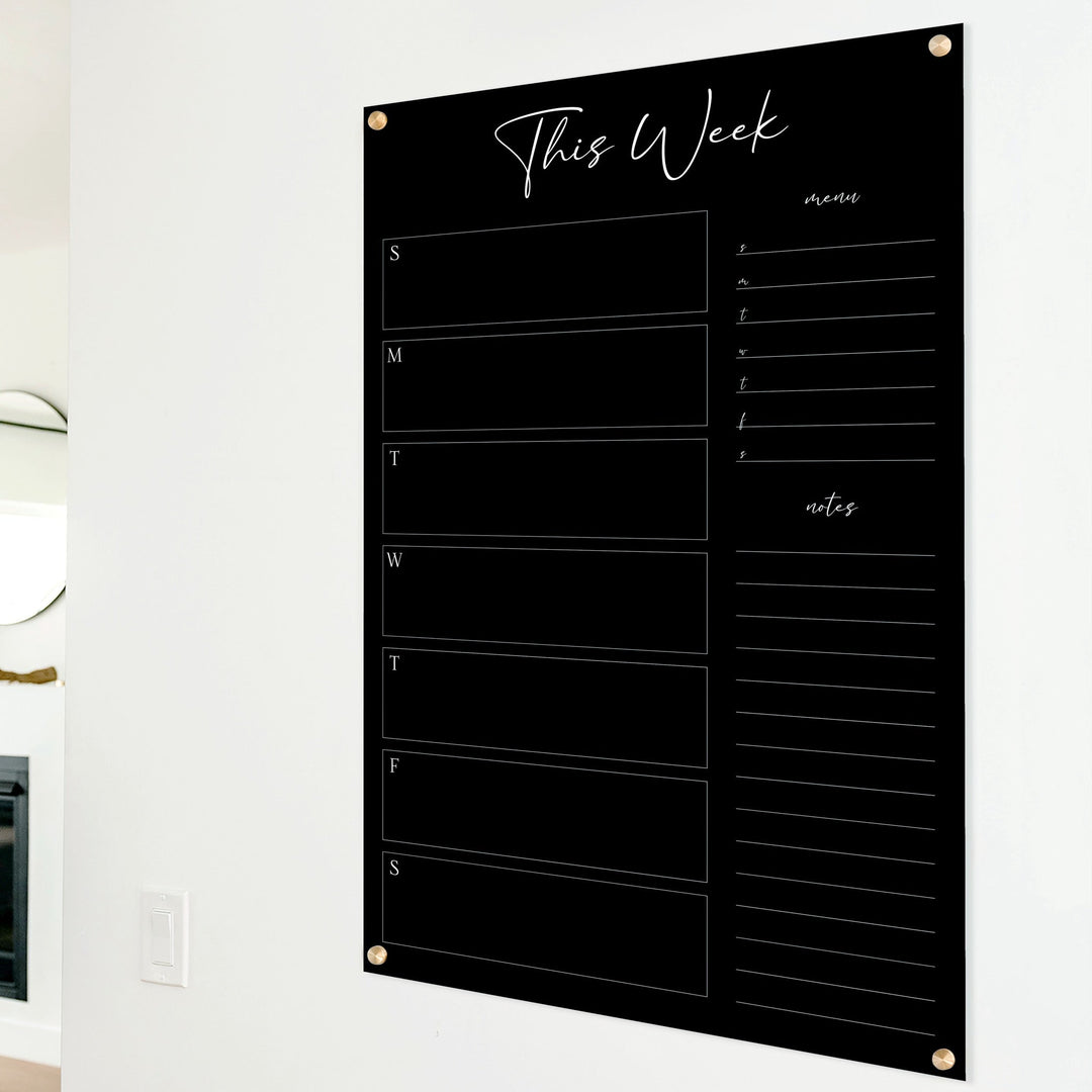 A Dry-erase weekly calender made of acrylic hanging on the wall