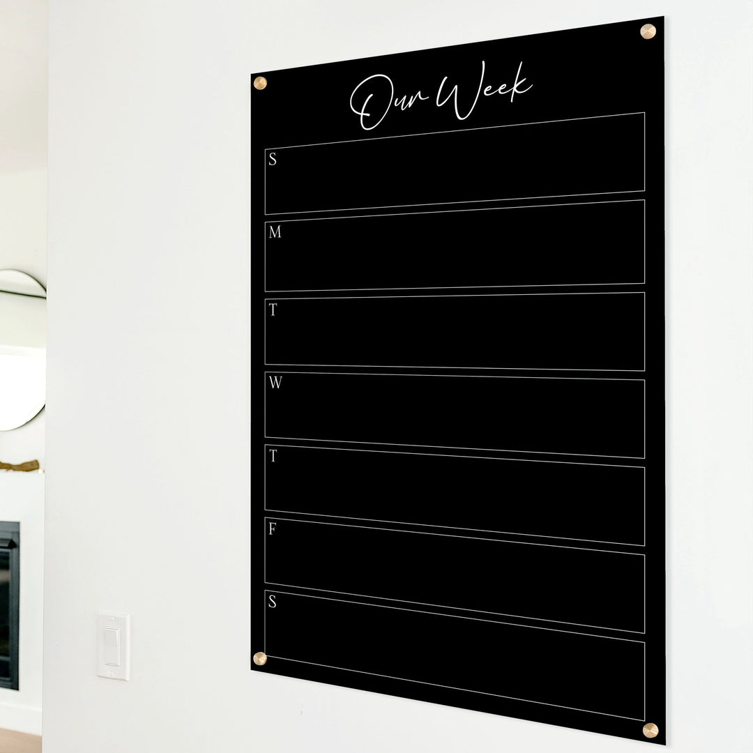 A Dry-erase weekly calender made of acrylic hanging on the wall