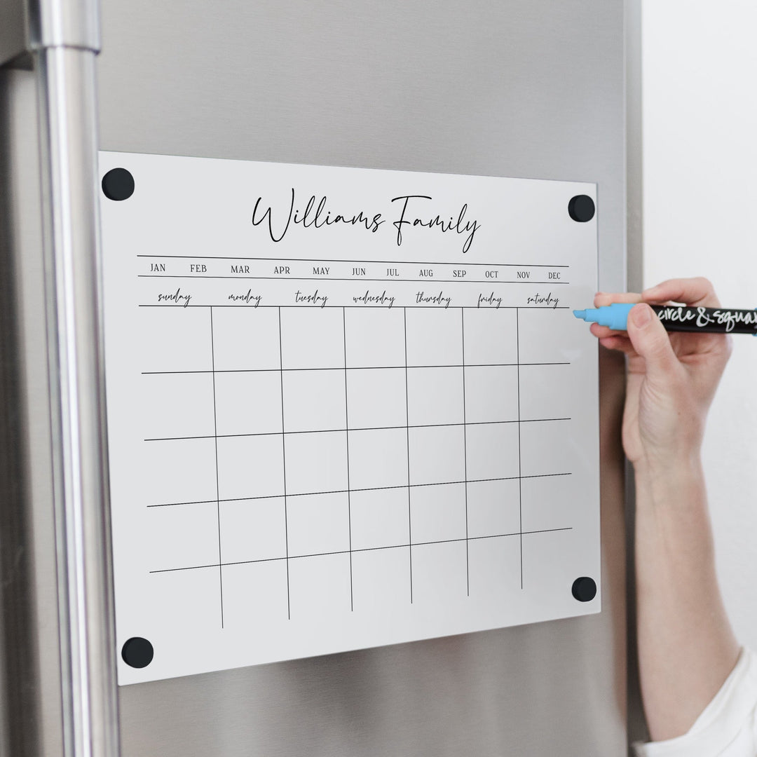 A Dry-erase monthly calender made of magnetic acrylic hanging on the fridge