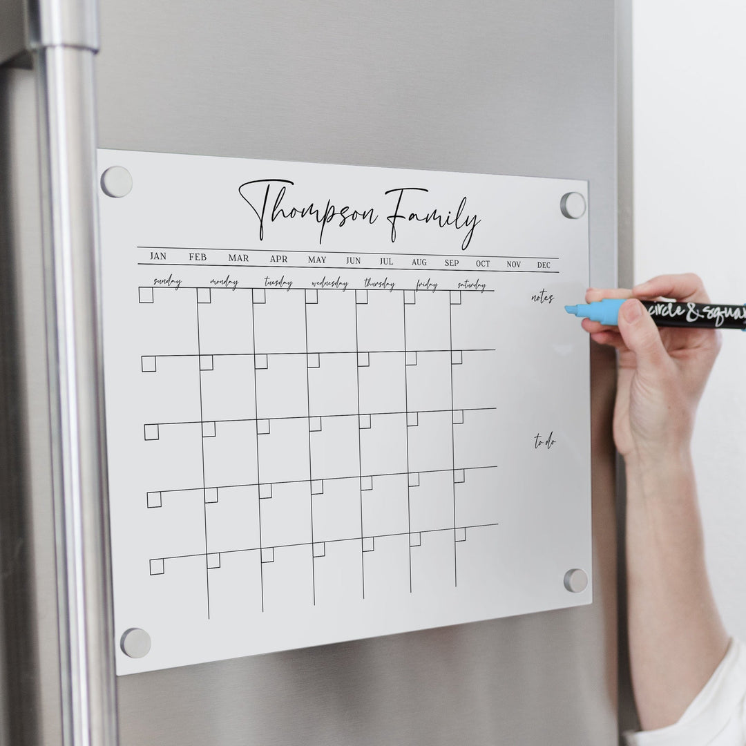 A Dry-erase monthly calender made of magnetic acrylic hanging on the fridge