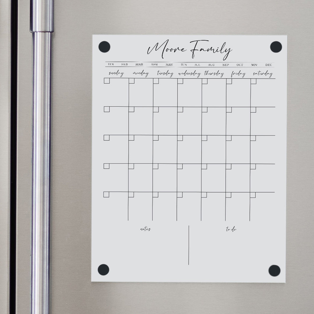 A Dry-erase monthly calender made of magnetic acrylic hanging on the fridge