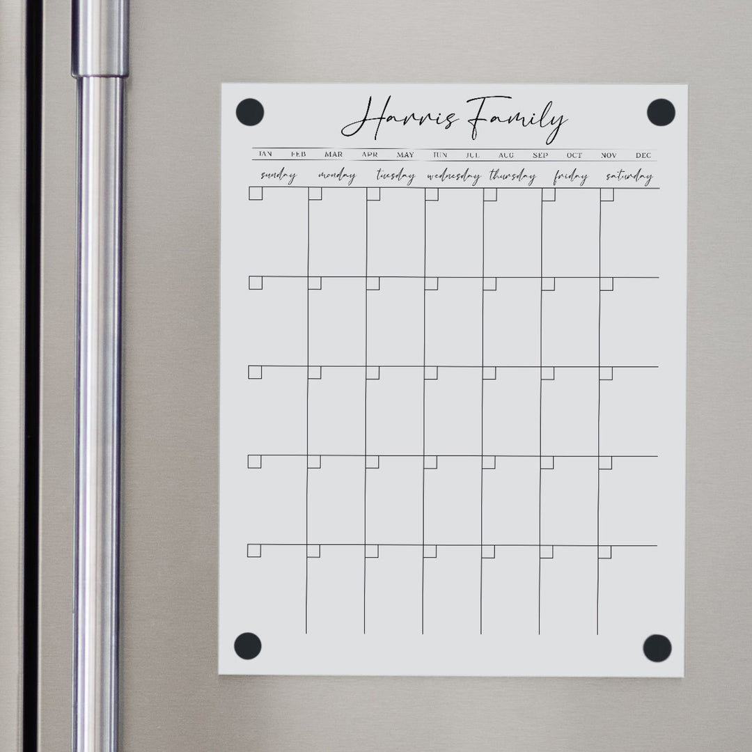A Dry-erase monthly calender made of magnetic acrylic hanging on the fridge