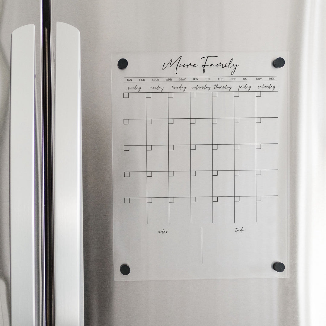 A Dry-erase monthly calender made of magnetic acrylic hanging on the fridge