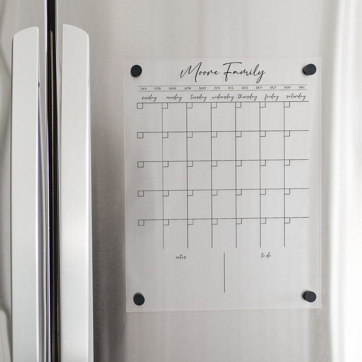 A Dry-erase monthly calender made of magnetic acrylic hanging on the fridge