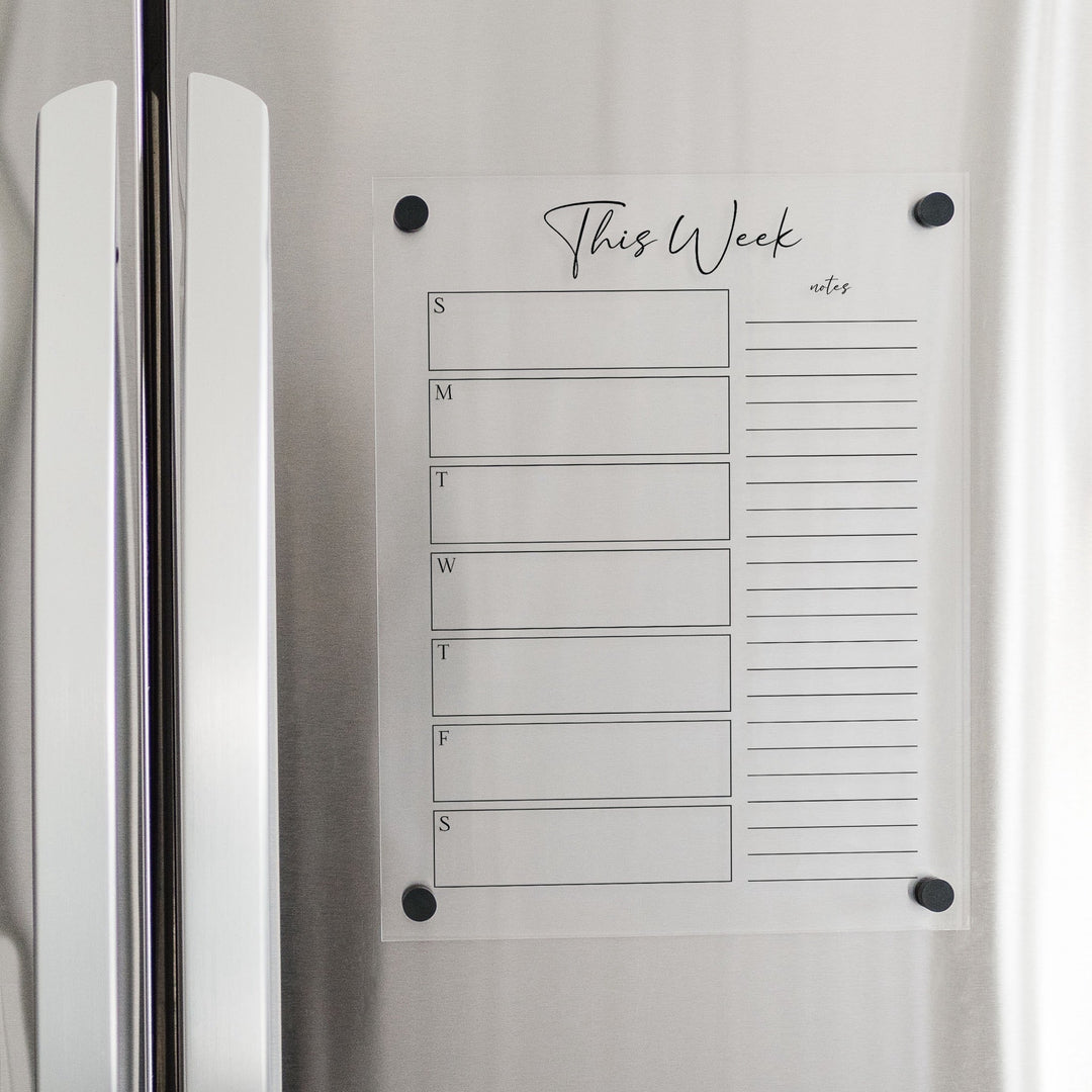 A Dry-erase weekly calender made of magnetic acrylic hanging on the fridge