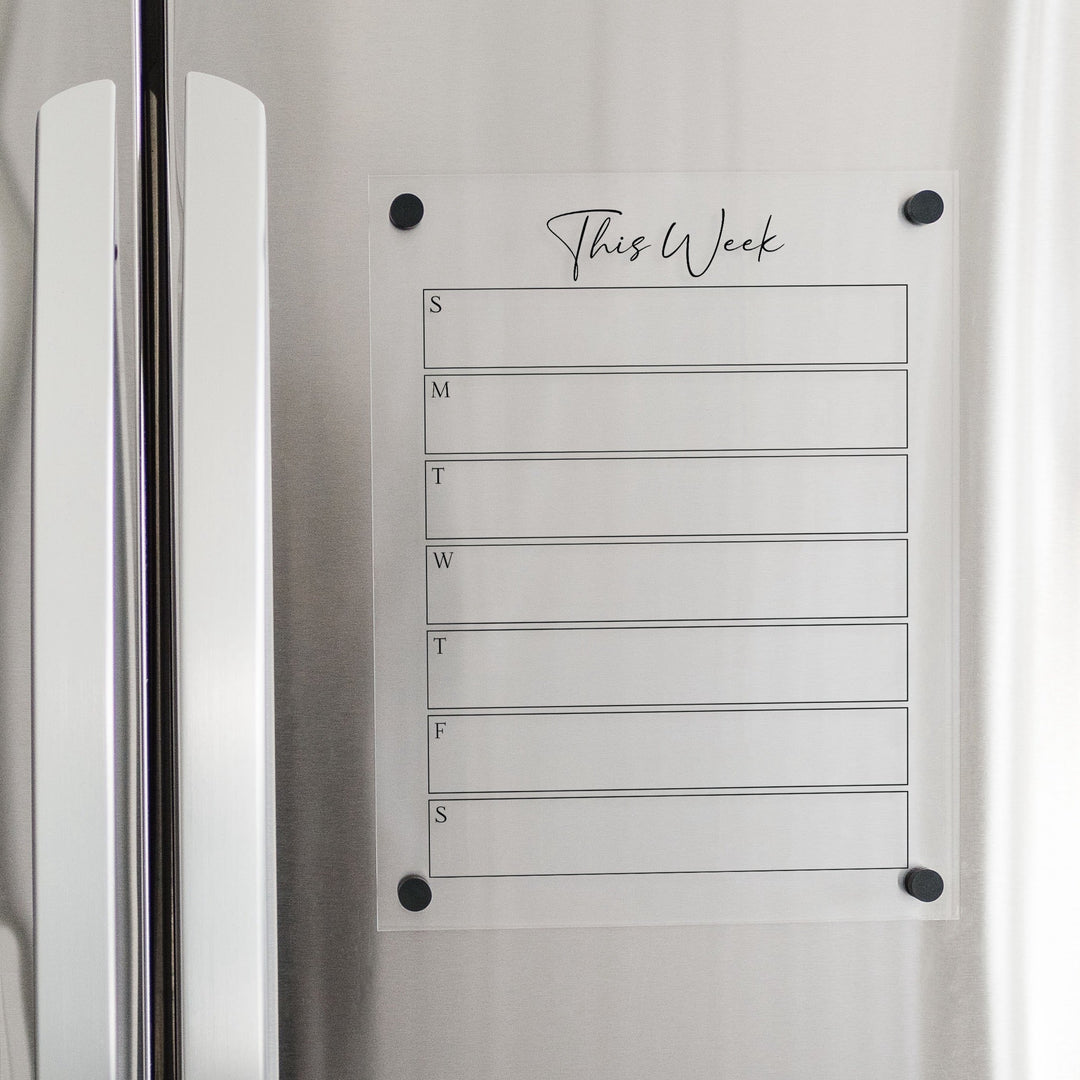 A Dry-erase weekly calender made of magnetic acrylic hanging on the fridge