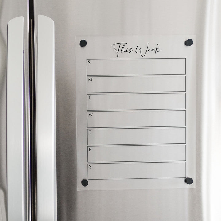 A Dry-erase weekly calender made of magnetic acrylic hanging on the fridge