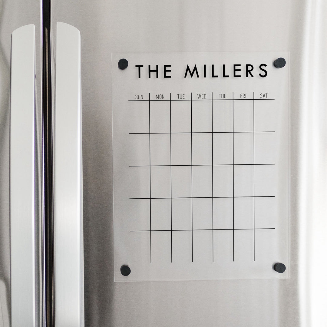 A Dry-erase monthly calender made of magnetic acrylic hanging on the fridge