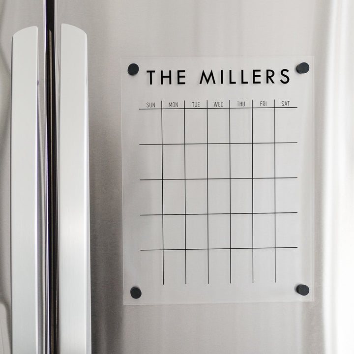 A Dry-erase monthly calender made of magnetic acrylic hanging on the fridge