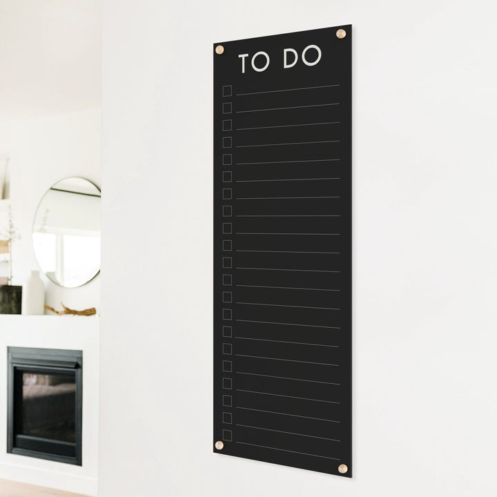 A dry-erase to do list made of acrylic hanging on the wall
