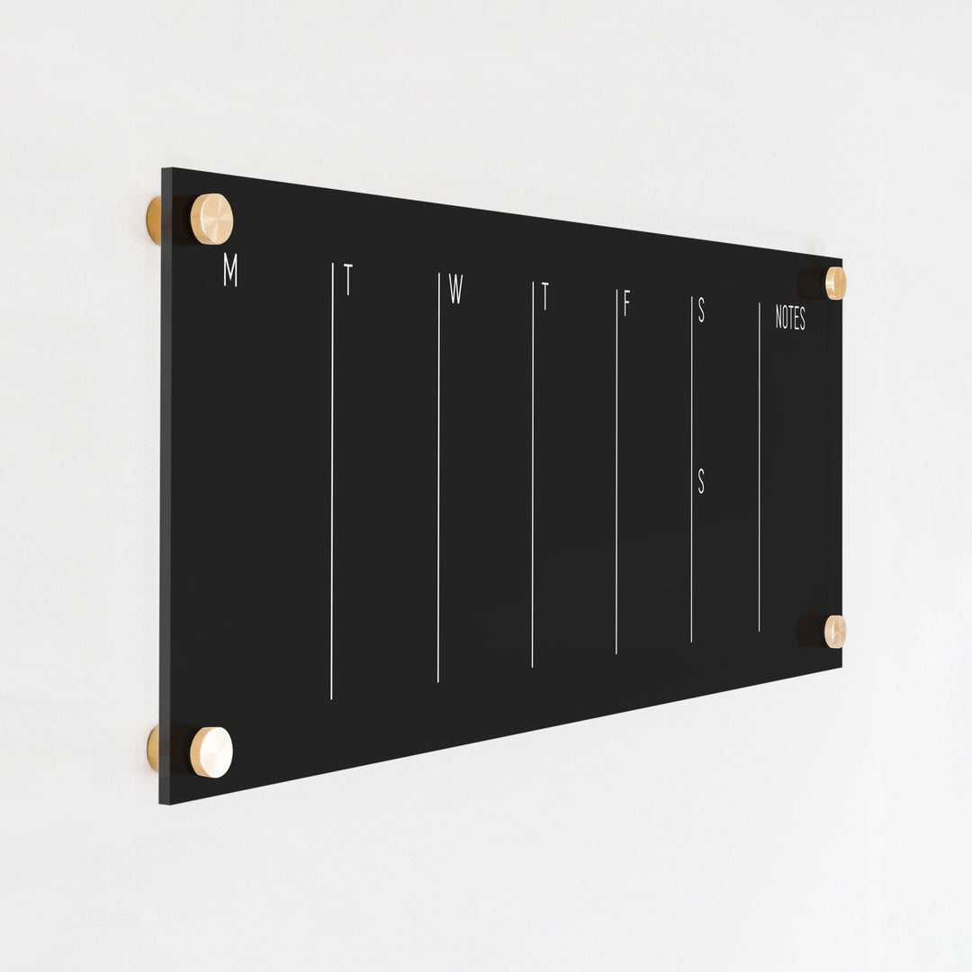 A skinny dry-erase weekly calender made of acrylic hanging on the wall