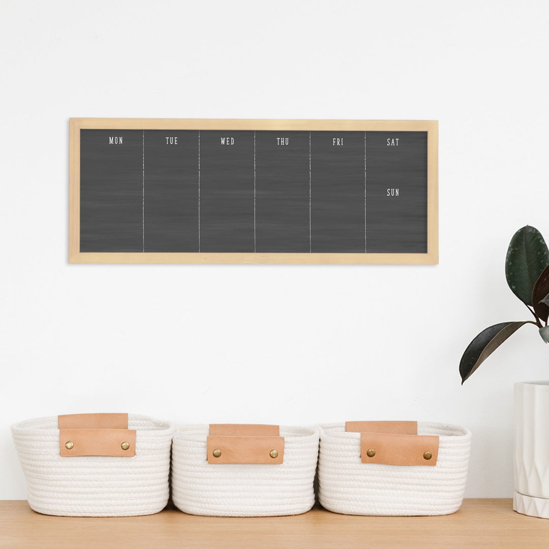 A framed whiteboard calendar with a two month design format hanging on the wall
