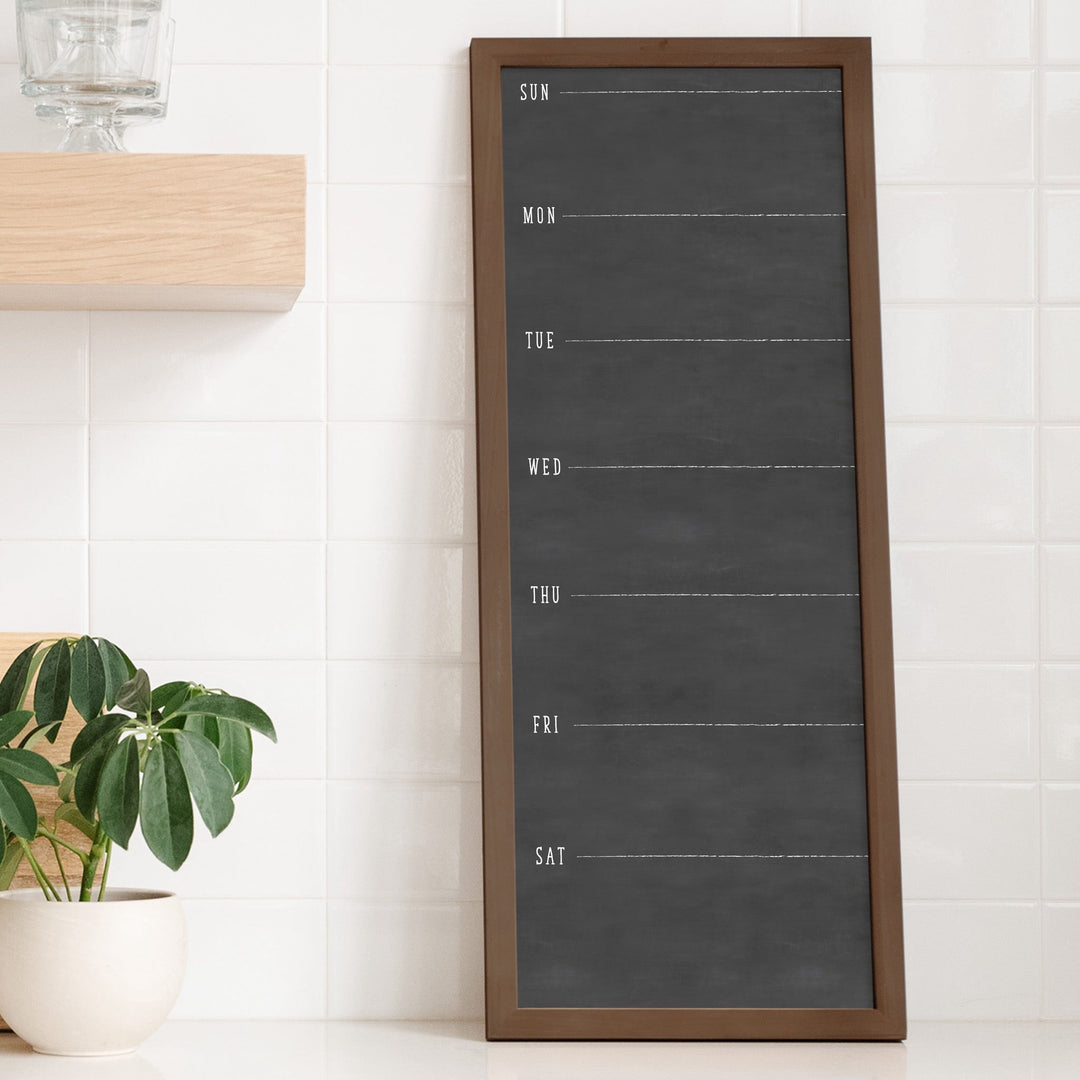 A framed whiteboard to do list hanging on the wall