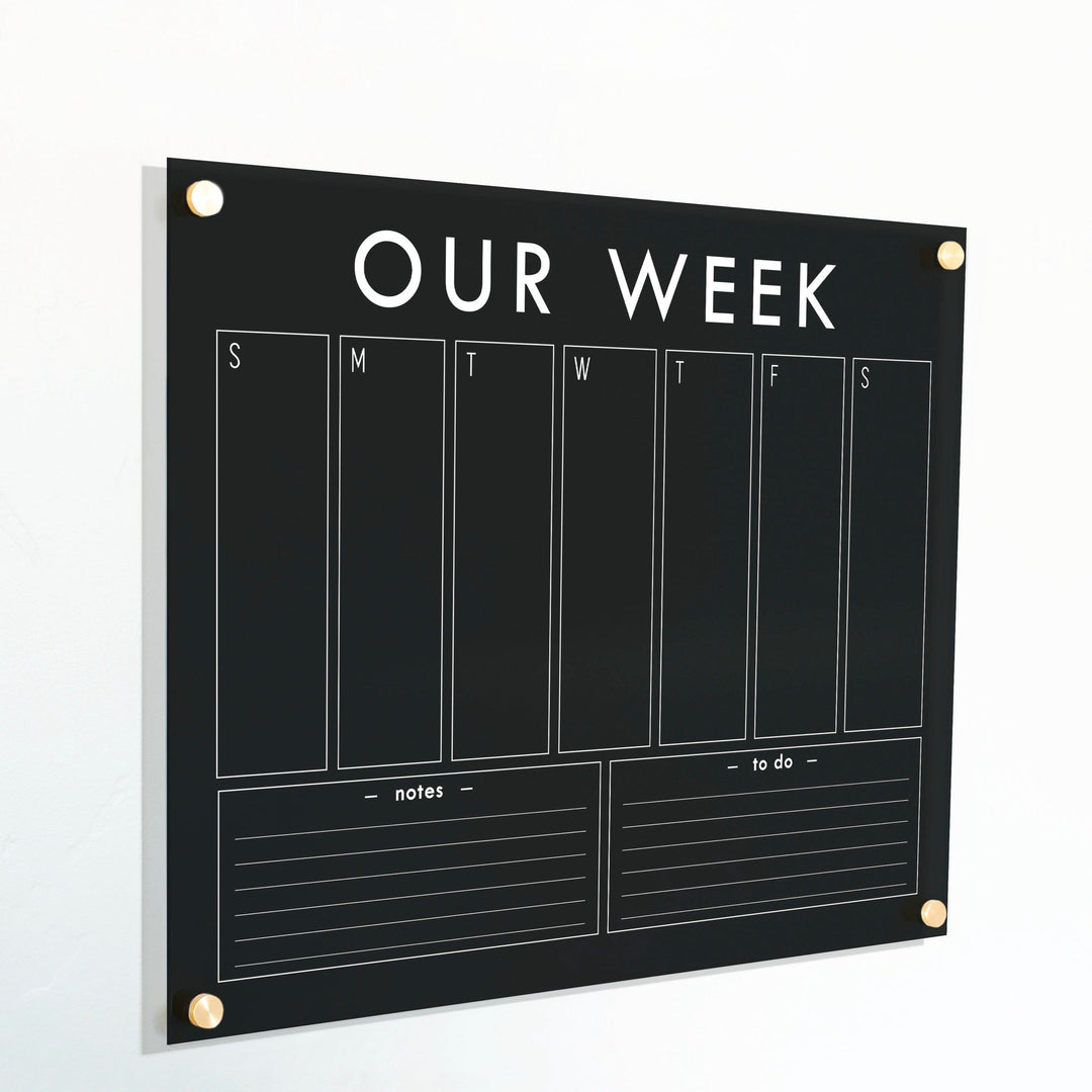 A Dry-erase weekly calender made of acrylic hanging on the wall