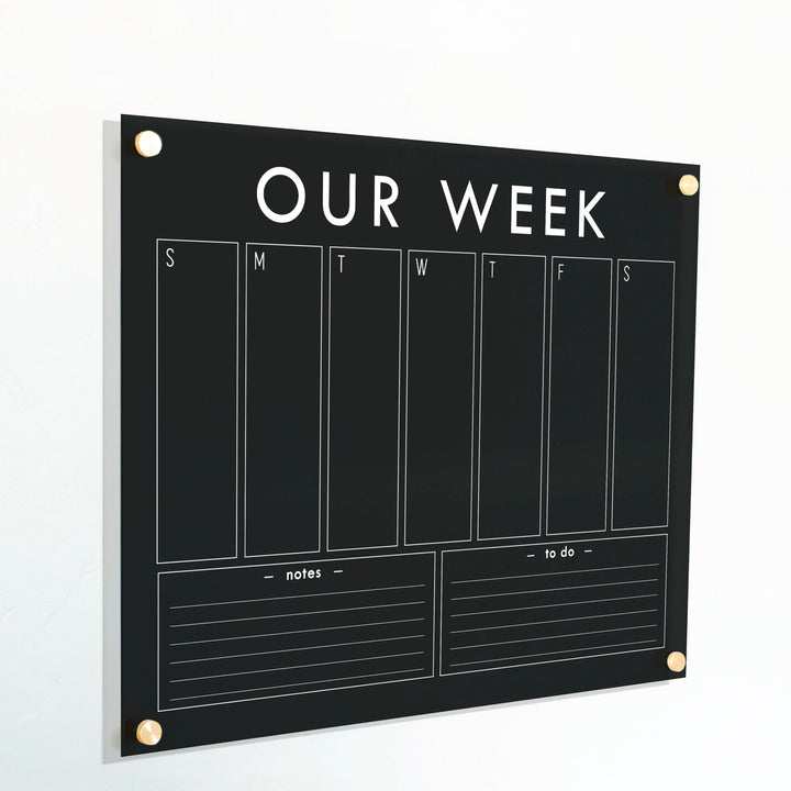A Dry-erase weekly calender made of acrylic hanging on the wall