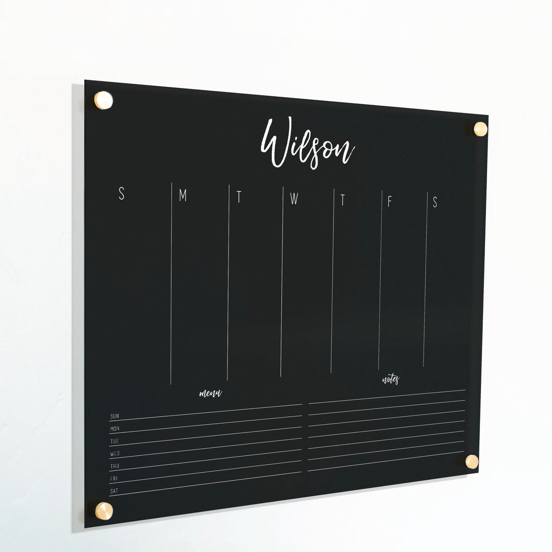 A Dry-erase weekly calender made of acrylic hanging on the wall