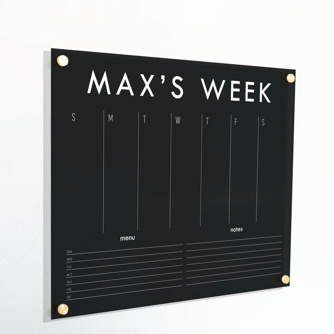 A Dry-erase weekly calender made of acrylic hanging on the wall