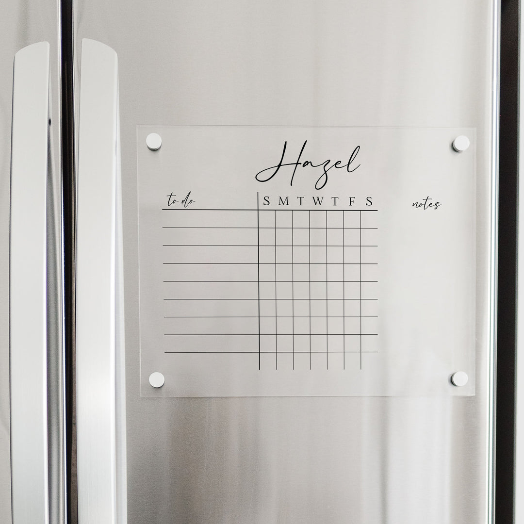A Dry-erase acrylic chore chart hanging on the fridge