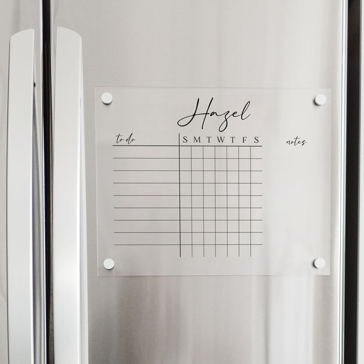 A Dry-erase acrylic chore chart hanging on the fridge
