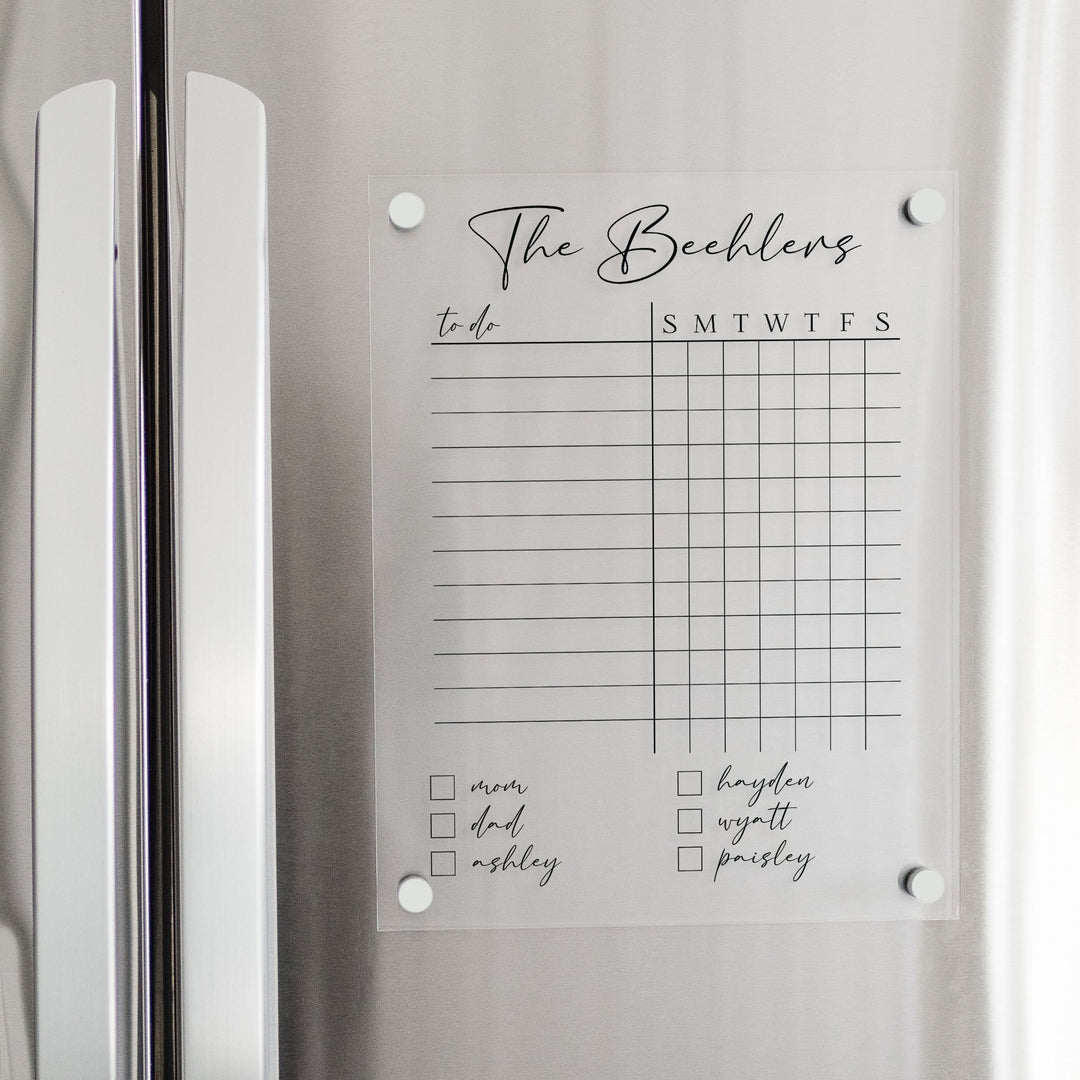 A Dry-erase acrylic chore chart hanging on the fridge
