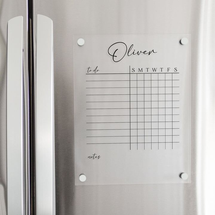 A Dry-erase acrylic chore chart hanging on the fridge