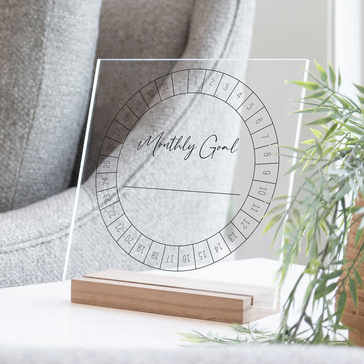 A monthly goal tracker design printed in black on a clear acrylic.