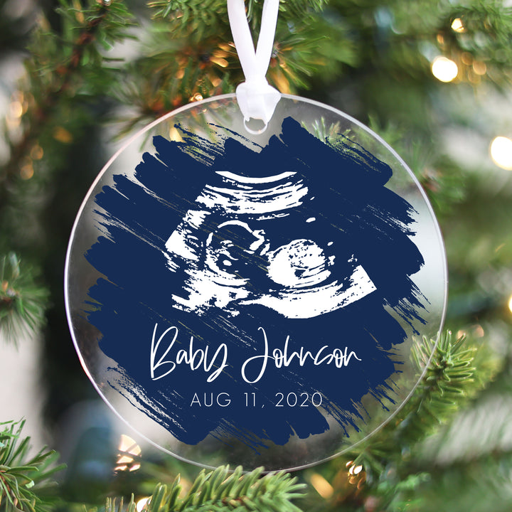 A Christmas ornament featuring an ultrasound on a navy brushed background.