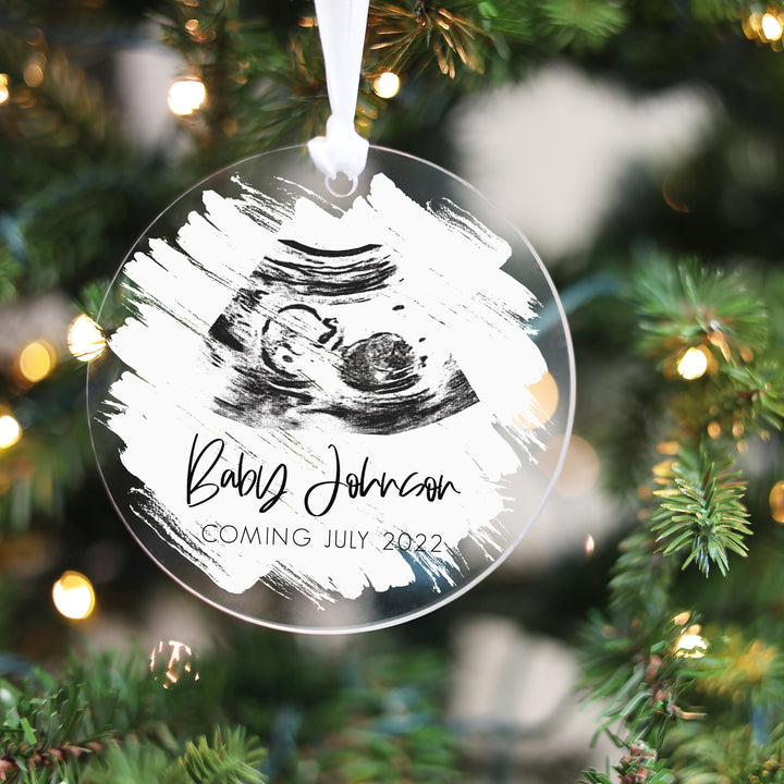 A Christmas ornament featuring an ultrasound with a white brushed paint background.