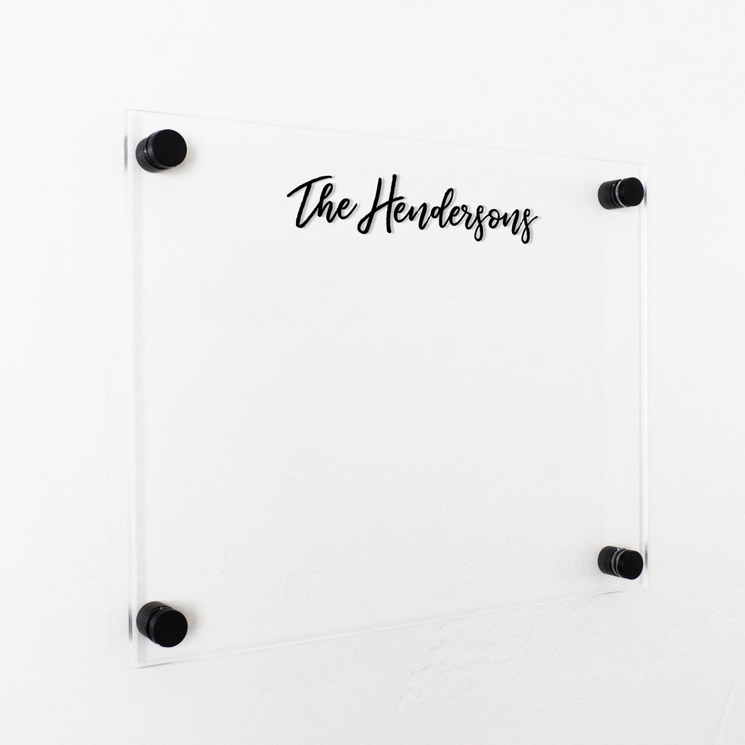 A dry-erase board made of clear acrylic with a custom title up top