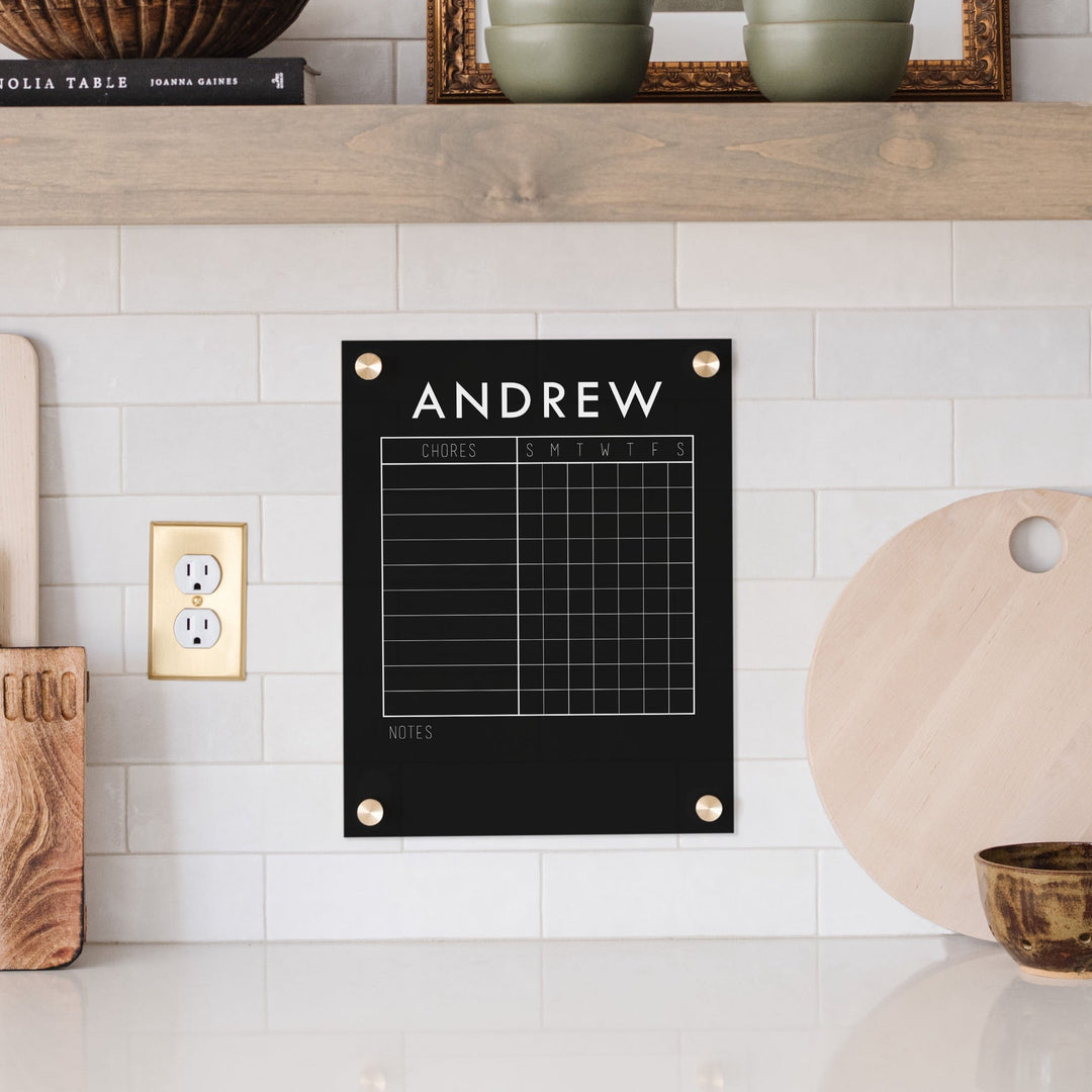 A Dry-erase acrylic chore chart hanging on the wall