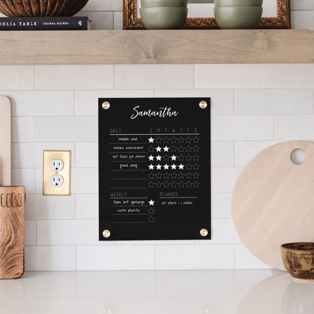A Dry-erase acrylic reward chart hanging on the wall