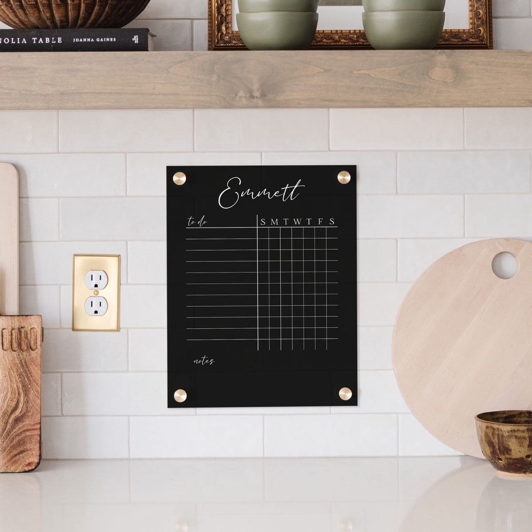 A Dry-erase acrylic chore chart hanging on the wall