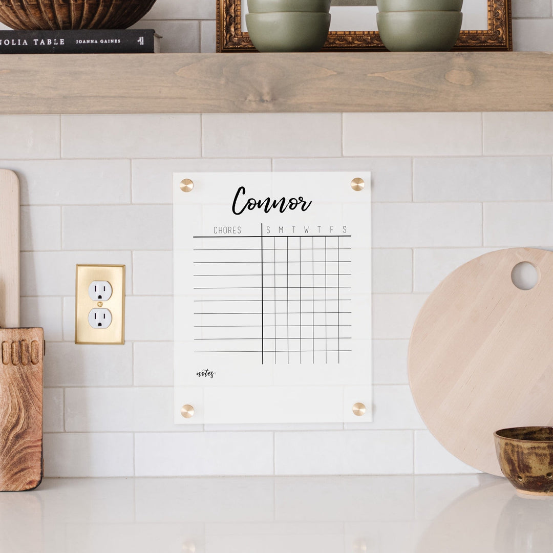 A Dry-erase acrylic chore chart hanging on the wall