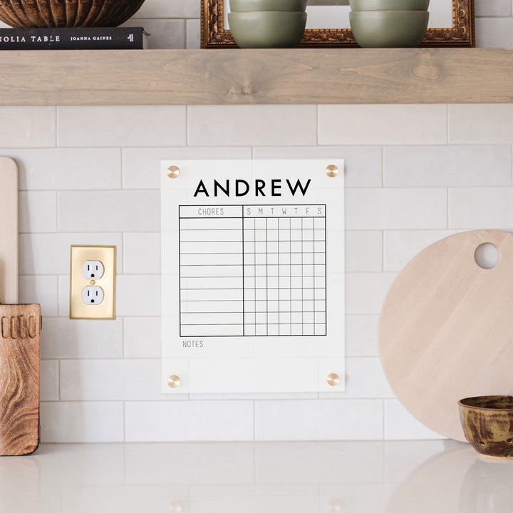 A Dry-erase acrylic chore chart hanging on the wall