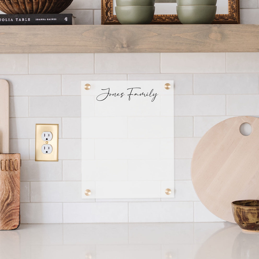 A dry-erase board made of clear acrylic with a custom title up top