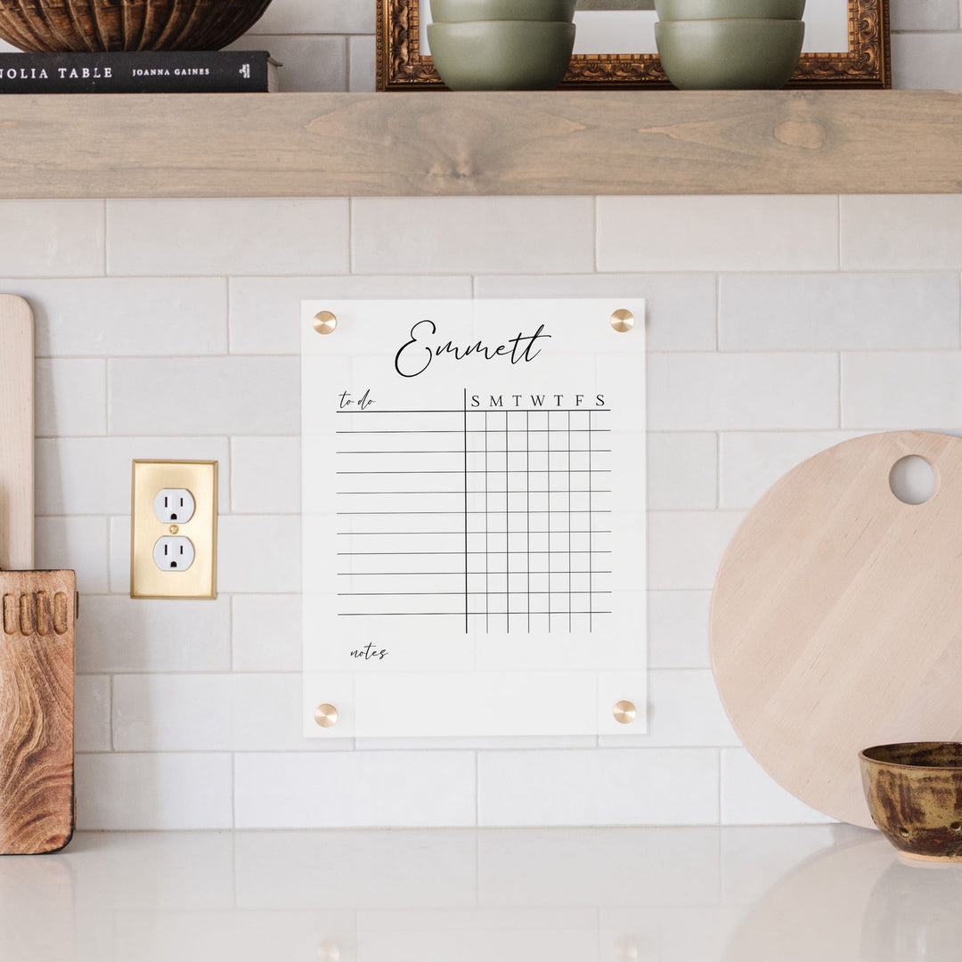 A Dry-erase acrylic chore chart hanging on the wall