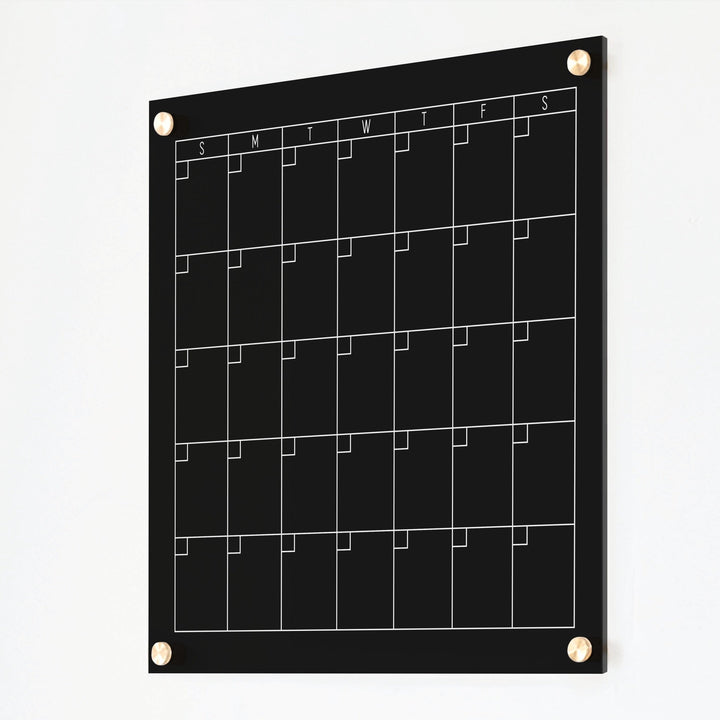 A Dry-erase monthly calender made of acrylic hanging on the wall