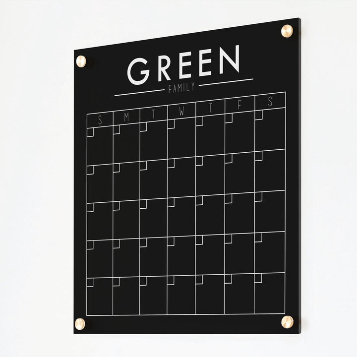 A Dry-erase monthly calender made of acrylic hanging on the wall