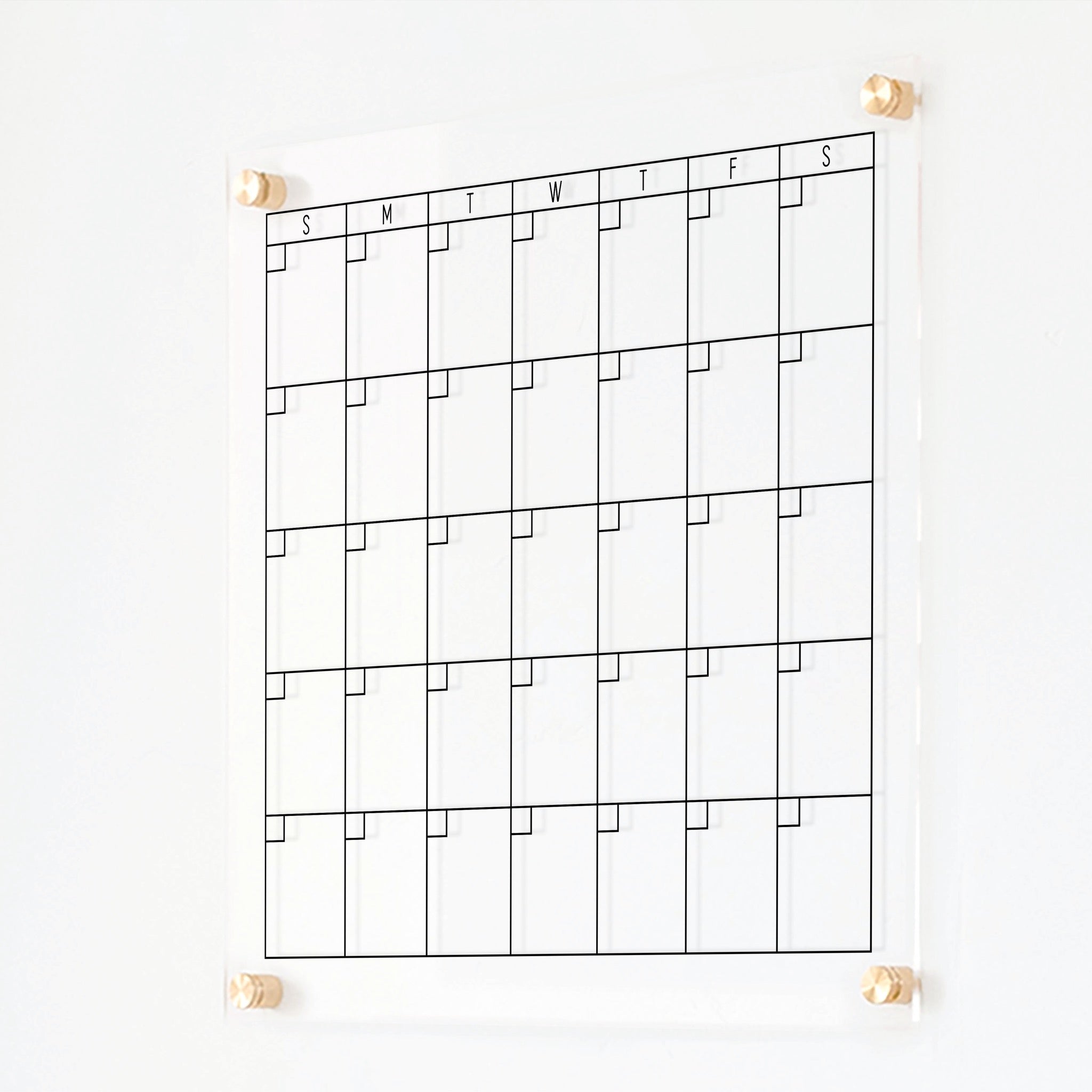 A Dry-erase monthly calender made of acrylic hanging on the wall