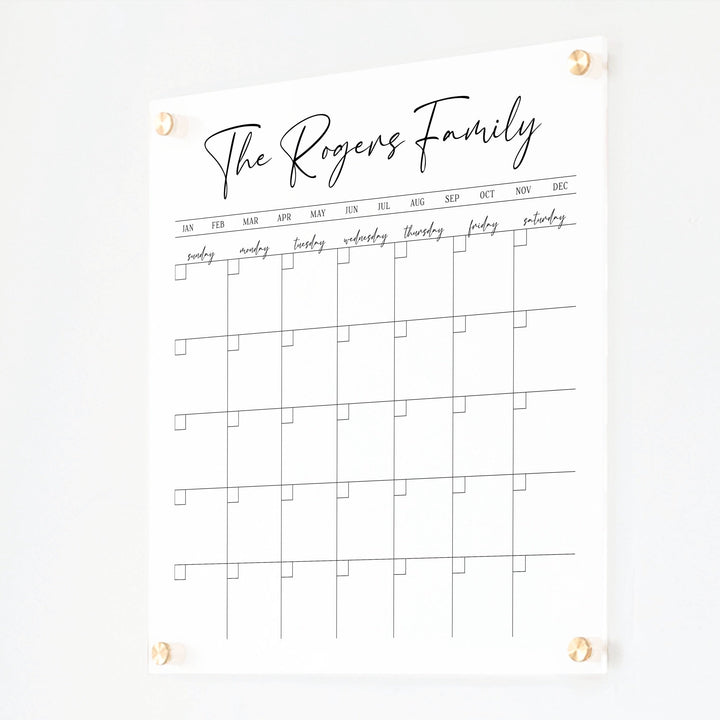 A Dry-erase monthly calender made of acrylic hanging on the wall