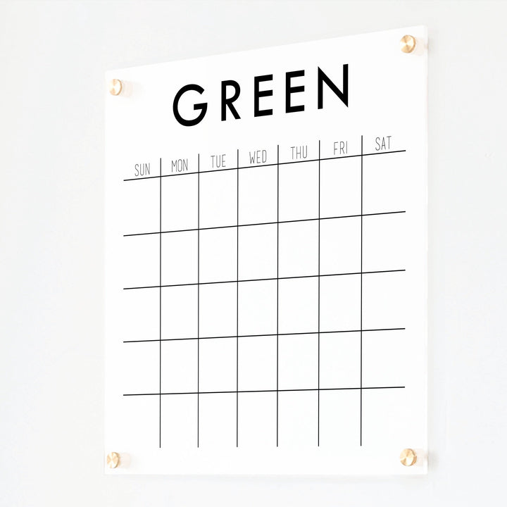 A Dry-erase monthly calender made of acrylic hanging on the wall