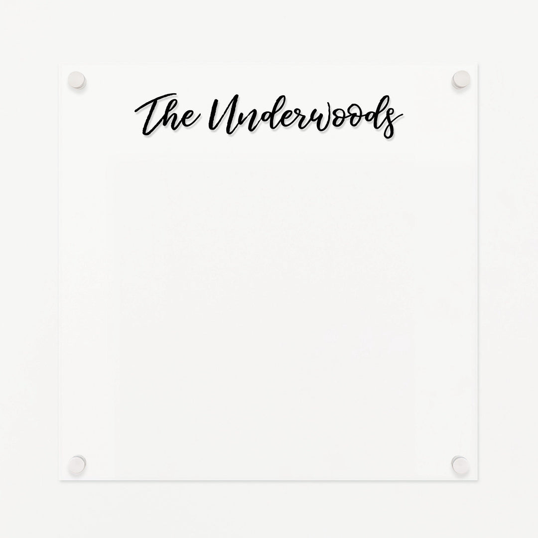 A dry-erase board made of clear acrylic with a custom title up top